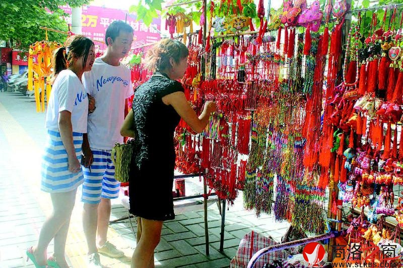 文化廣場香包攤前造型各異、做工精美的香包吸引年輕人購買。