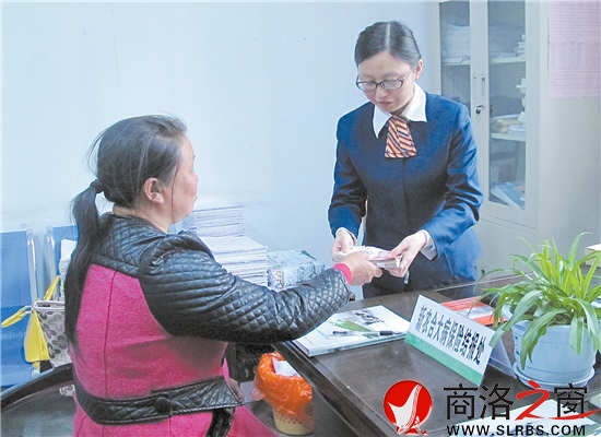 4月23日,謝自芳從工作人員手中接過大病保險報銷資金。