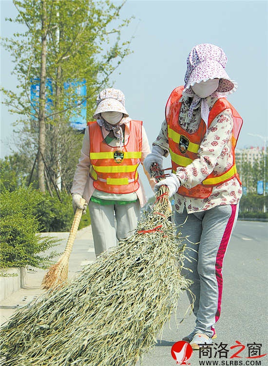 14時56分,室外溫度高達36攝氏度。記者在商鞅大道任家塬村路段看到兩名環衛工人“全副武裝”,正在賣力地清掃路面渣土。