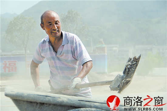 15點12分,來自商州區大趙峪辦事處的村民劉捆柱正在比亞迪大道上清運沙石。雖然已經滿頭大汗,但他仍然奮力地揮舞著鐵锨。