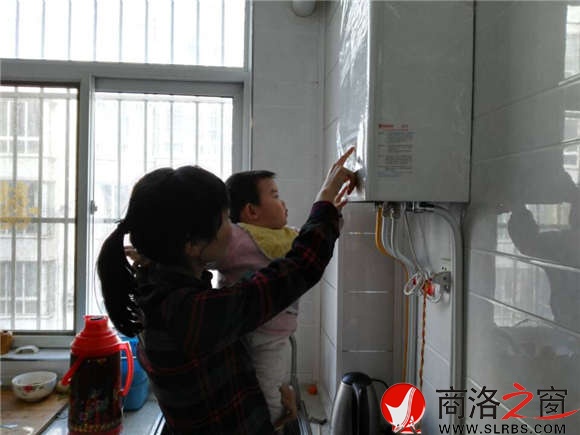 家住市區香菊小區的李女士正在操作自家剛剛安裝的燃氣壁掛爐,提升室內的溫度。