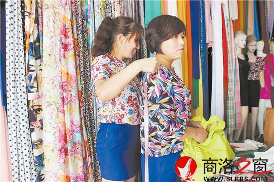 雷小莉仔細(xì)地為客人量尺寸，量體裁衣是裁縫鋪?zhàn)畲蟮膬?yōu)勢(shì)。